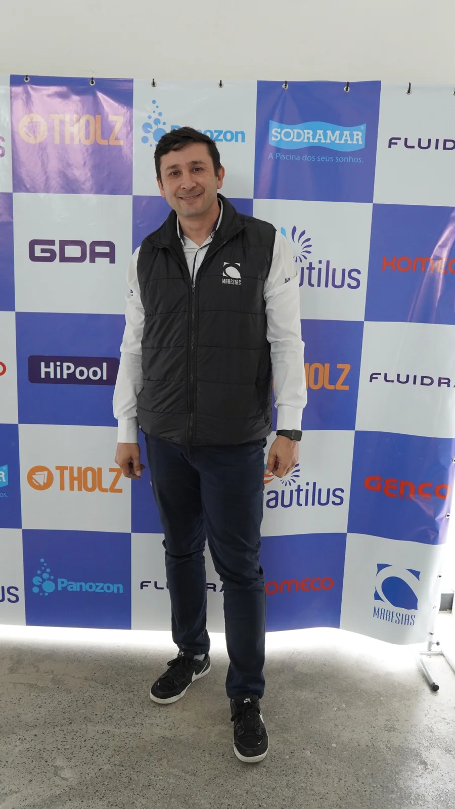 Representante de marca posando no painel do evento