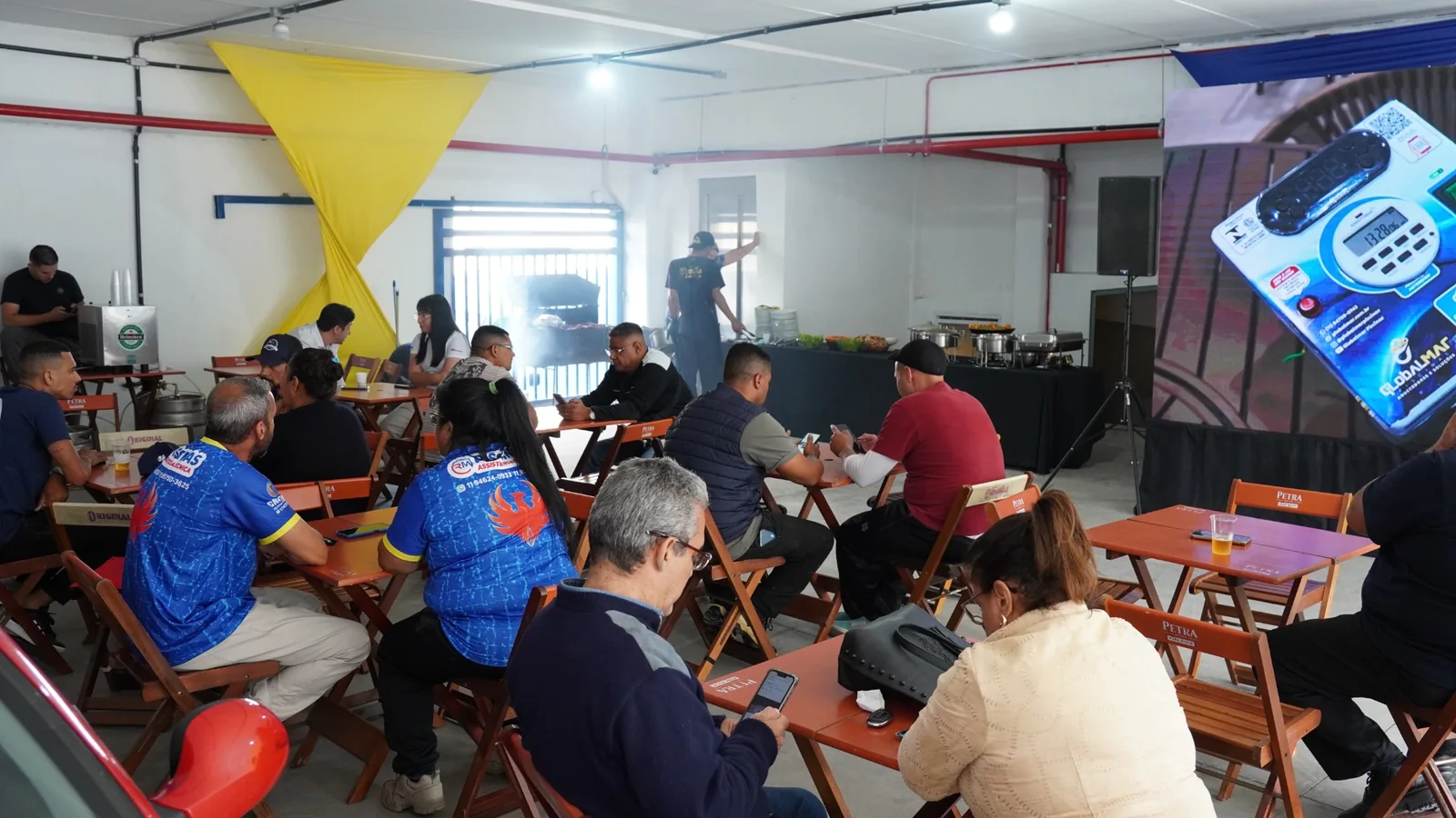 Participantes sentados na área de apresentação e buffet