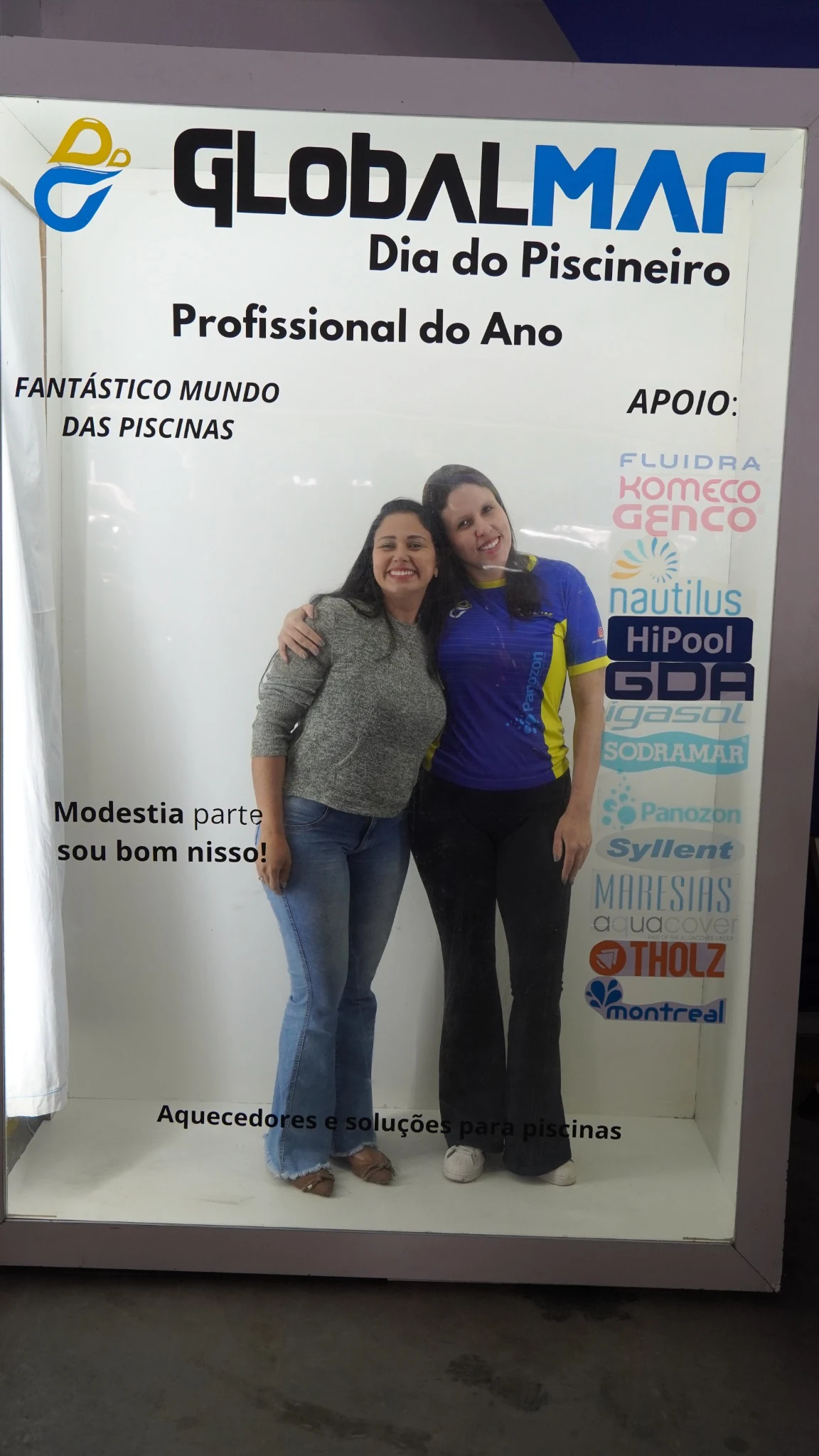 Duas participantes posando no painel do Dia do Piscineiro Profissional do Ano